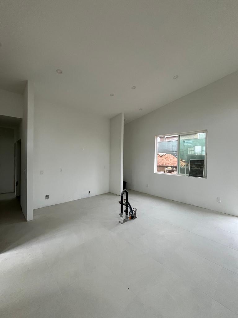 Primed living space with recessed lighting and new tile flooring.
