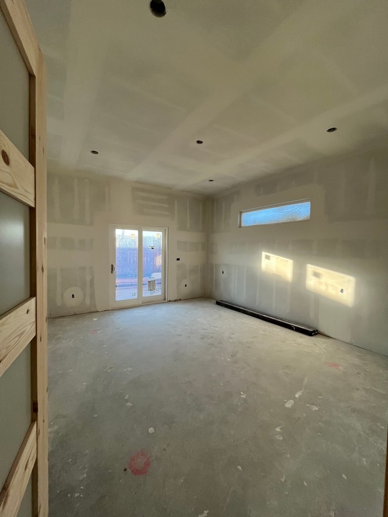 Finished drywall interior room prepared for flooring and trim installation.