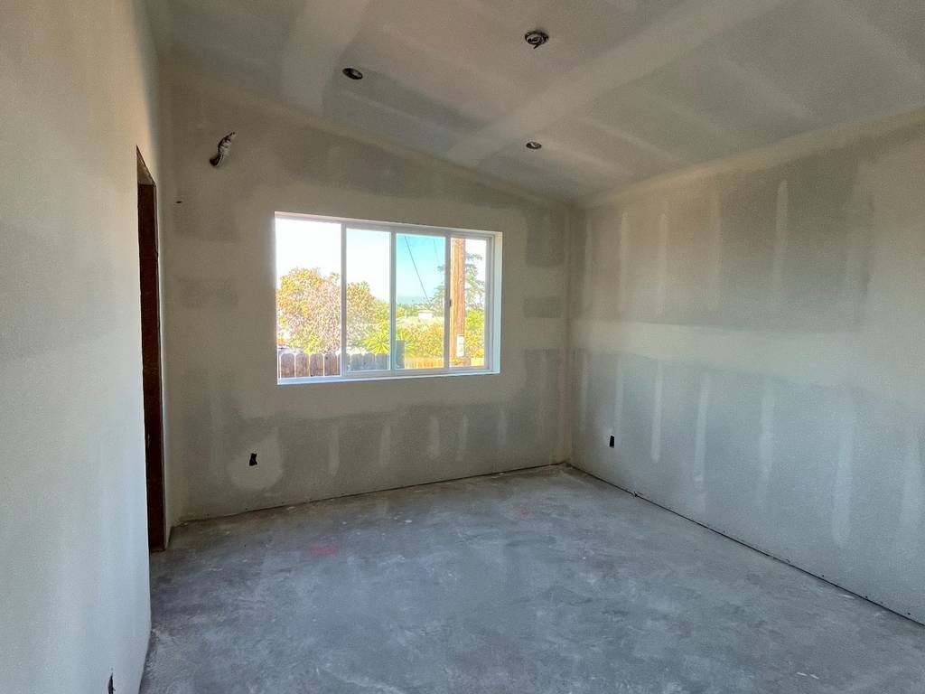 Drywall installation completed with recessed lighting in ceiling.