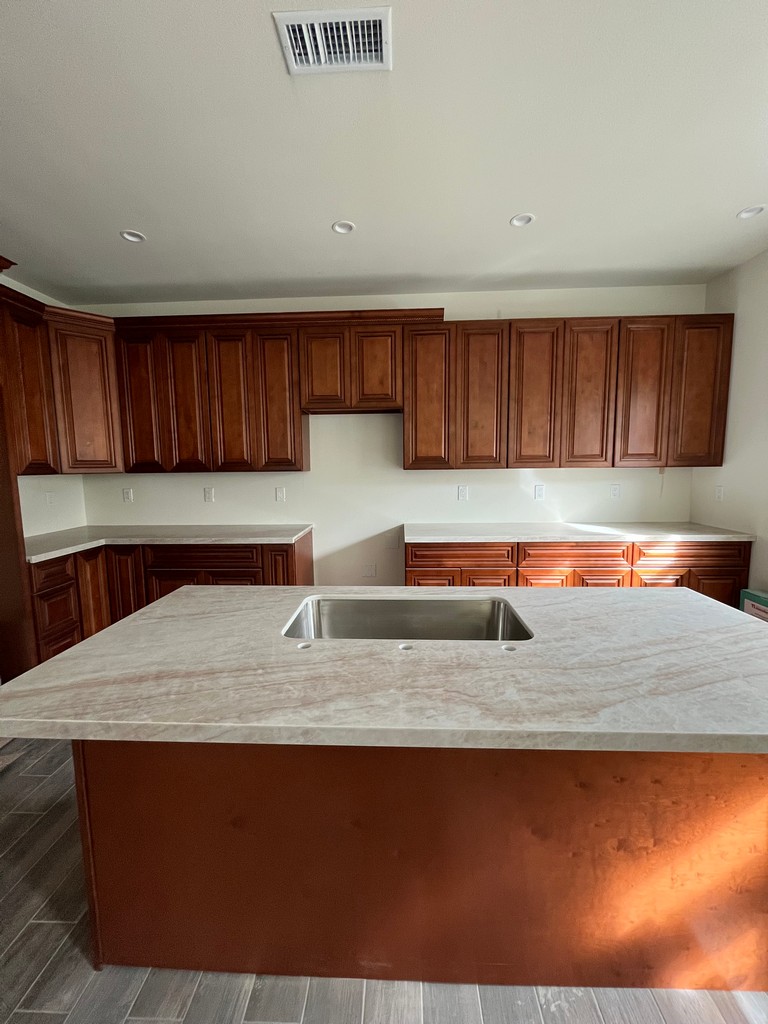 Kitchen island cabinet with stone countertop installed.