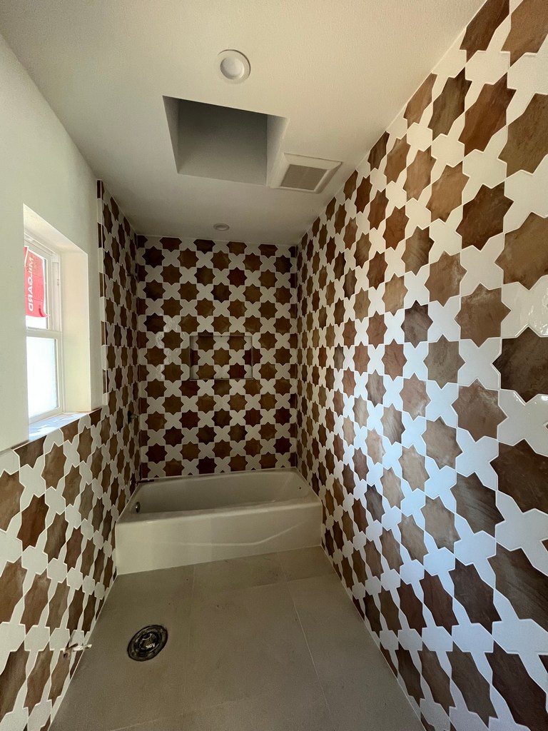 Bathroom wall tile installed around tub and shower area.