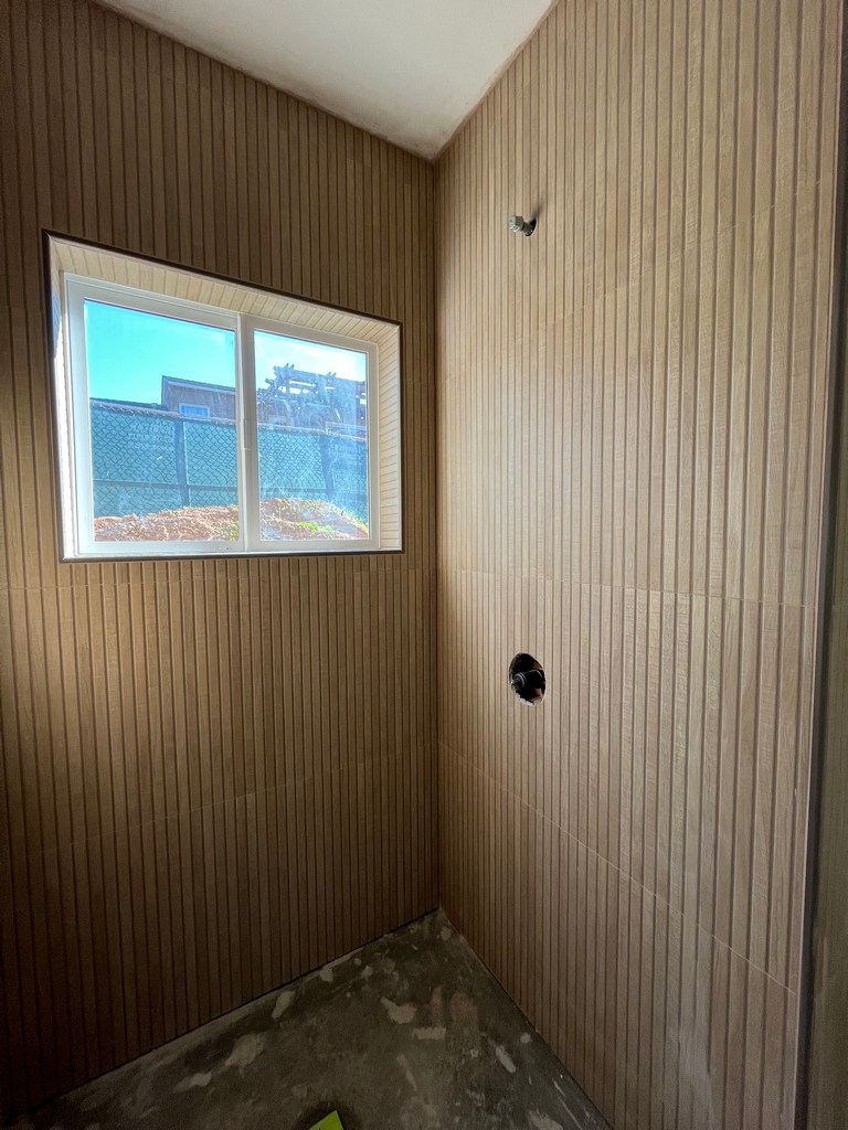 Vertical bathroom wall panels installed in shower area.