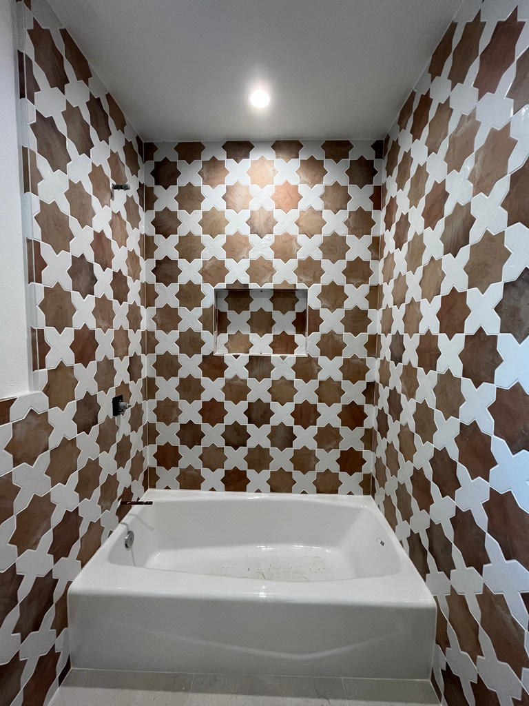 Bathroom patterned wall tile, recessed niche, and ceiling lighting