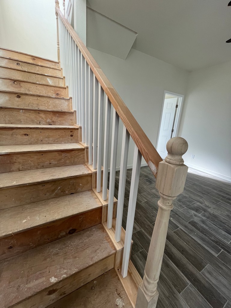 Interior stair railing and balusters installed during finish carpentry.