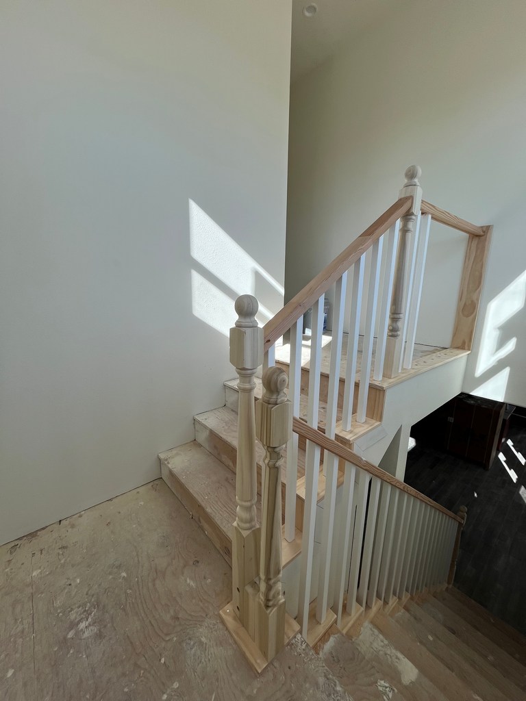 Wood staircase with newel posts and railing installed.
