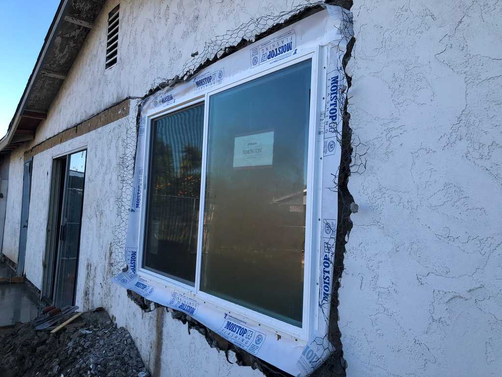 stucco removed around window frame for a front room remodel