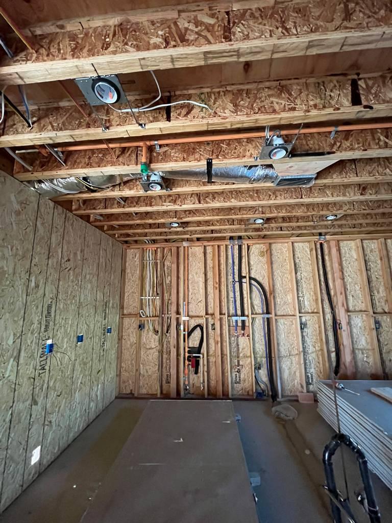 ** Interior mechanical rough-in showing copper plumbing, ductwork, and wall piping layout.