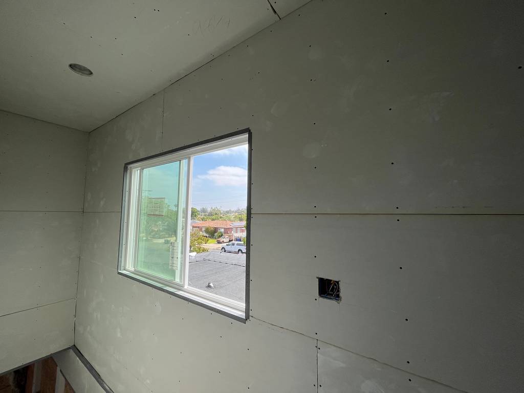 sheetrock applied to the walls and ceiling of bedroom of the home addition