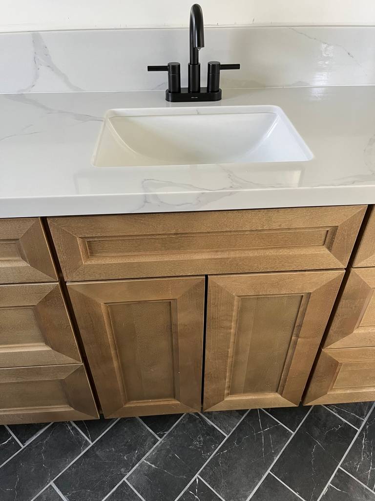 Bronze Gooseneck Faucet on Marble Countertop attached to a Beautiful Custom Design Wood Cabinet