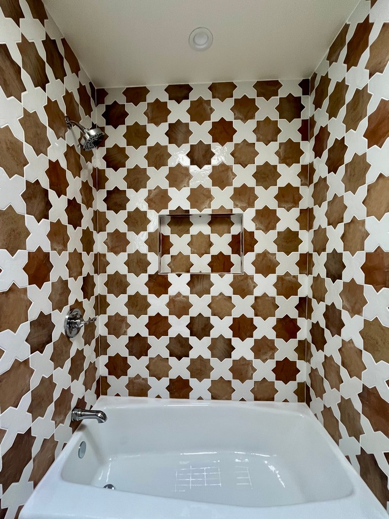Geometric tile shower and tub surround with niche.