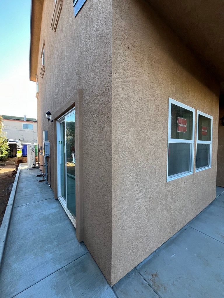 Stucco exterior corner with installed windows on new residential construction