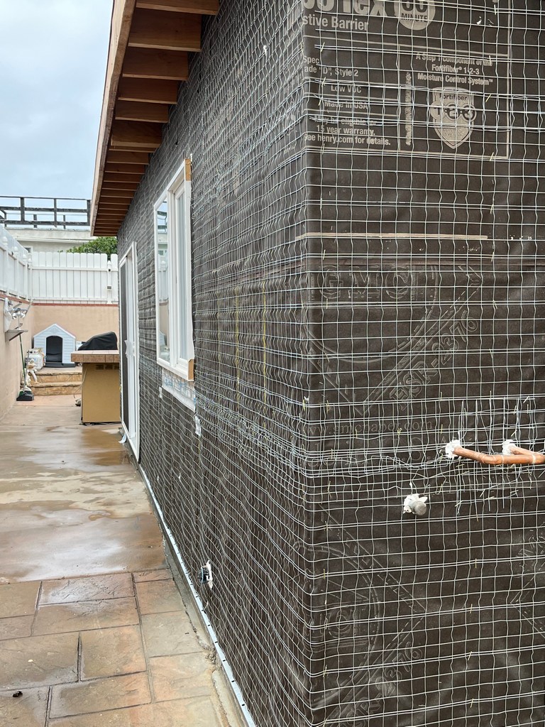 Side elevation with weather barrier and stucco lath installed, ready for exterior plaster finish.