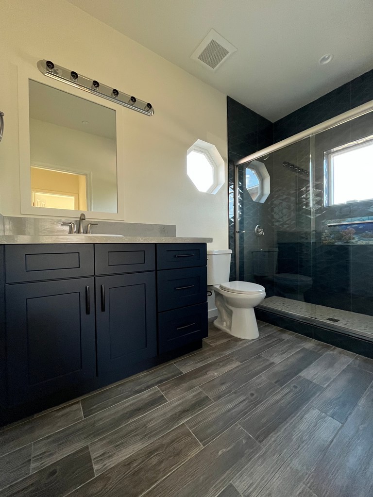 Bathroom vanity with tiled glass shower.