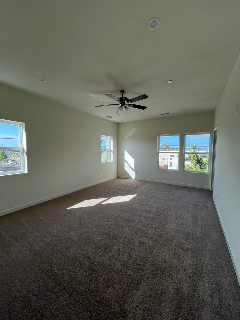 Finished bedroom with carpet and ceiling fan.