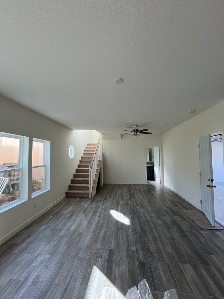 Open living space featuring staircase installation, plank flooring.