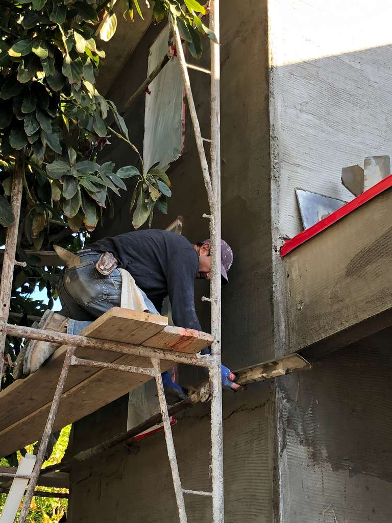 stucco-workers-floating-scratch-coat-on-home-addition