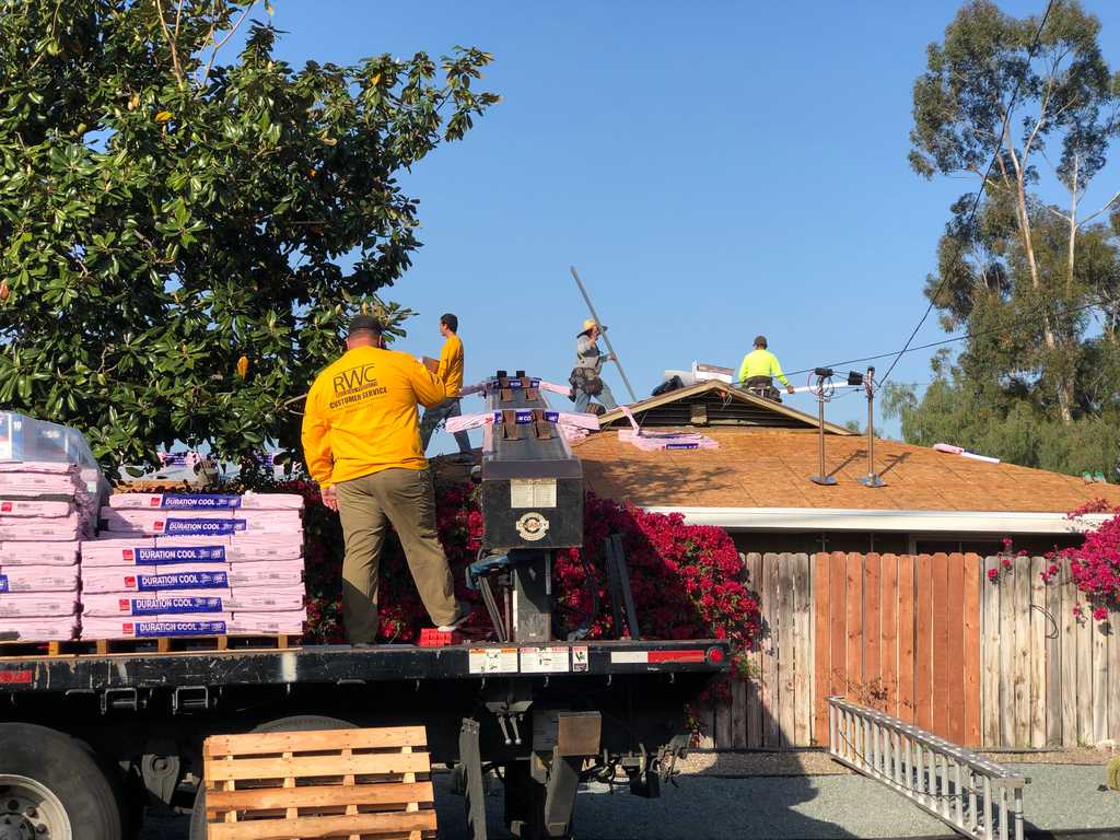 a2mContractors loading new shingles on the conveyor belt