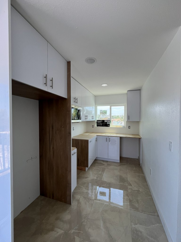 Kitchen cabinets with microwave and tile flooring