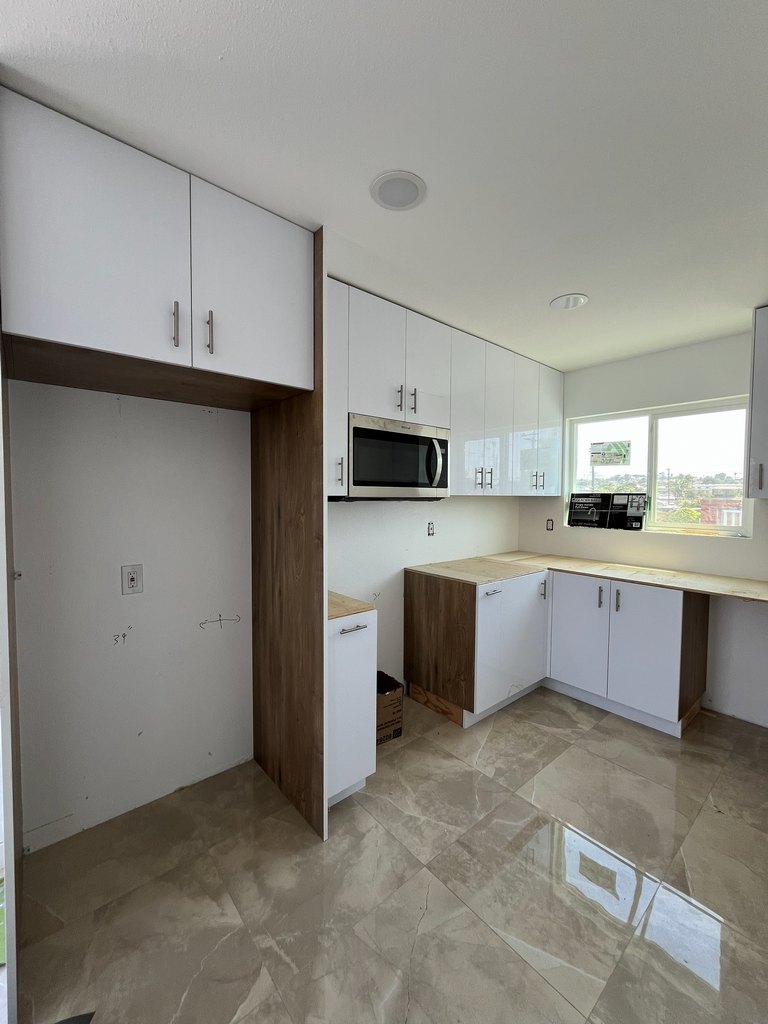 White and wood kitchen cabinetry with microwave