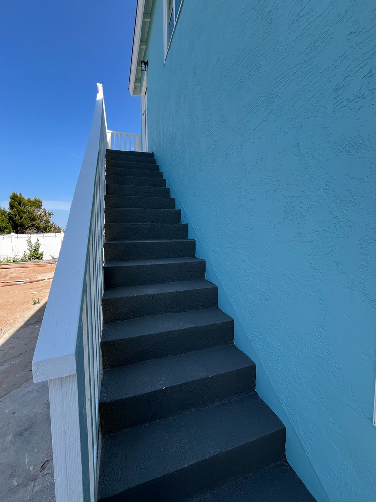 Finished exterior stairs with white railing
