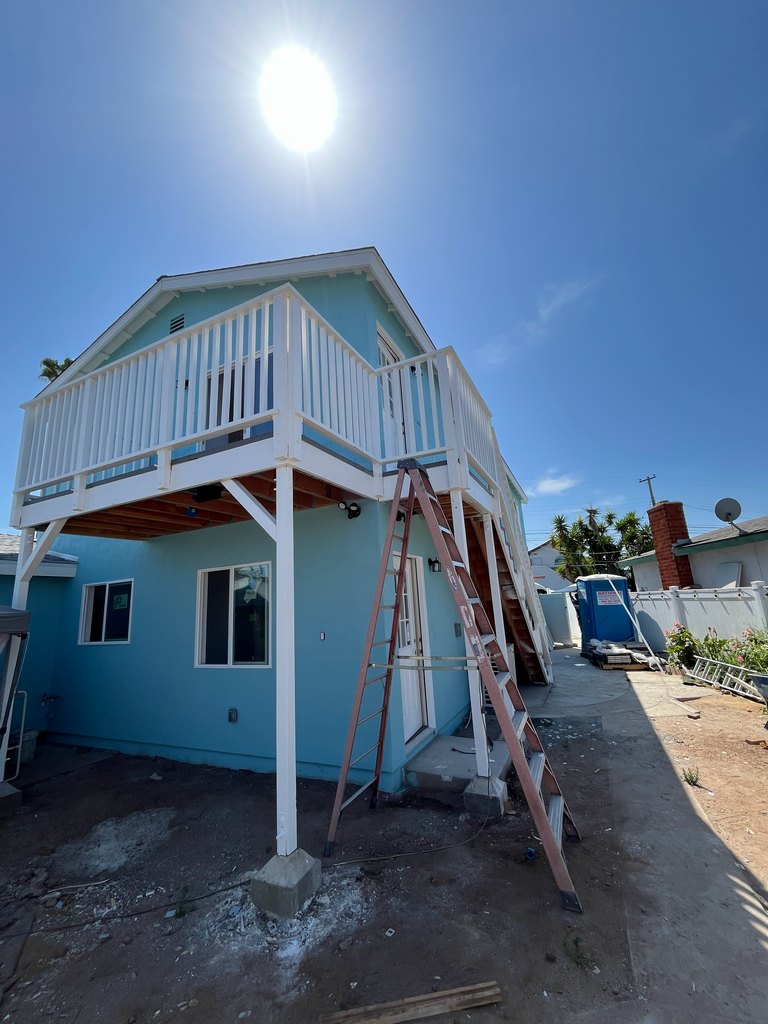 Blue guest house with white balcony railings