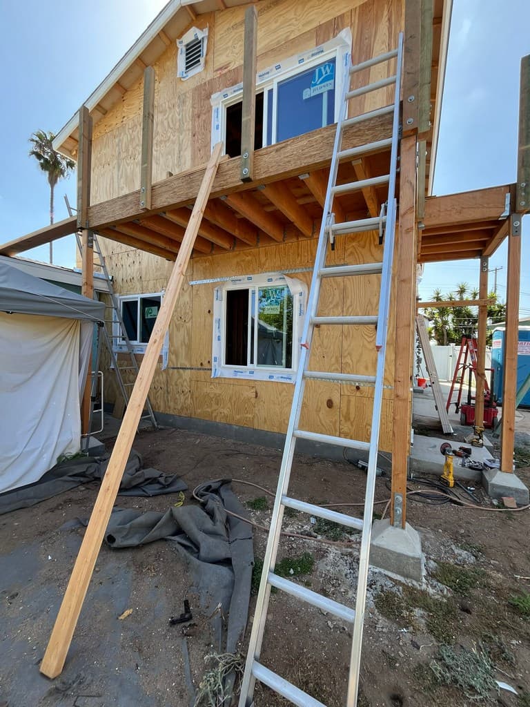 Vinyl windows beside framed ADU balcony.