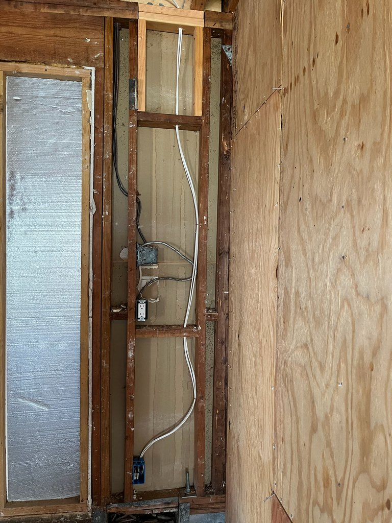 Long framed hallway showing electrical wiring,