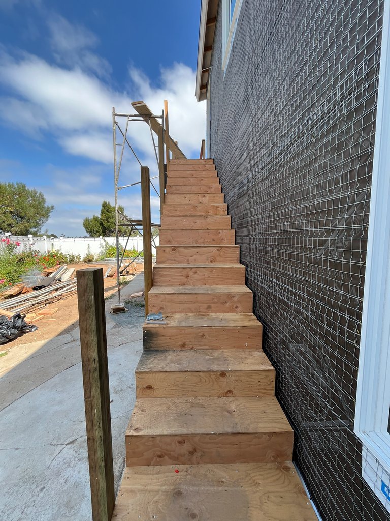 e newly framed plywood staircase beside metal stucco lath