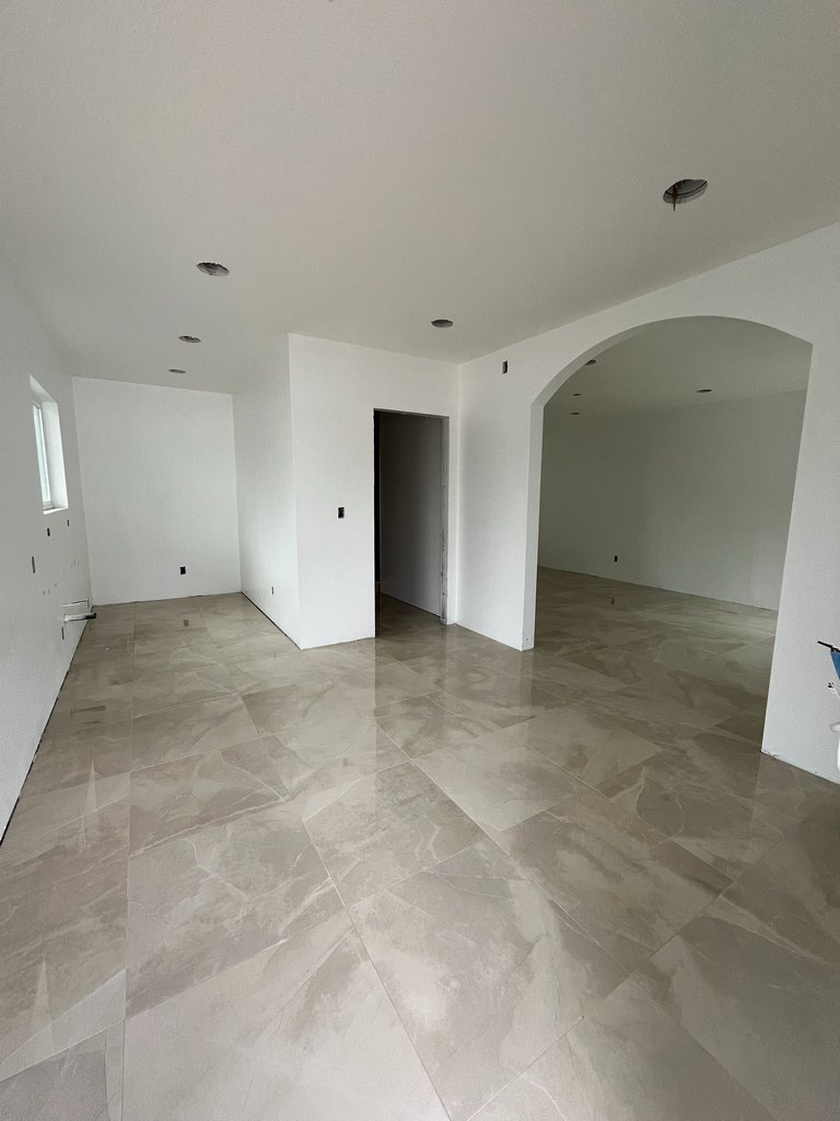 eflective tile flooring, white painted walls, an architectural archway