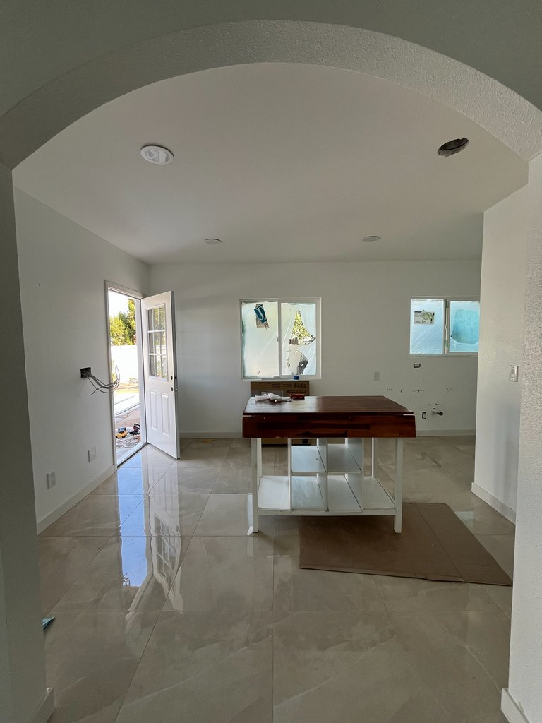 kitchen area with glossy tile flooring, painted walls, windows, an exterior door