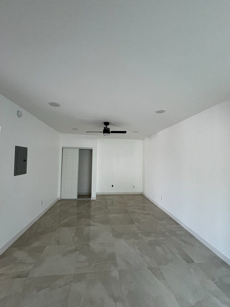 guest room showing reflective tile flooring, recessed lighting, a ceiling fan