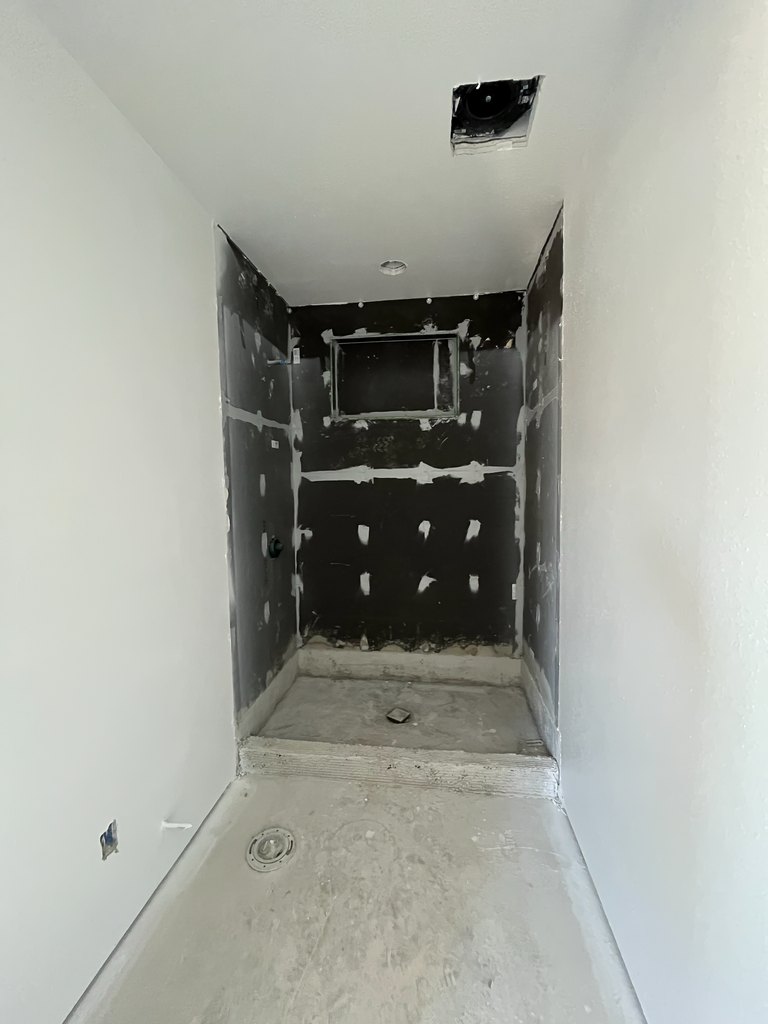 hower enclosure with joint-treated backer panels, a small window opening