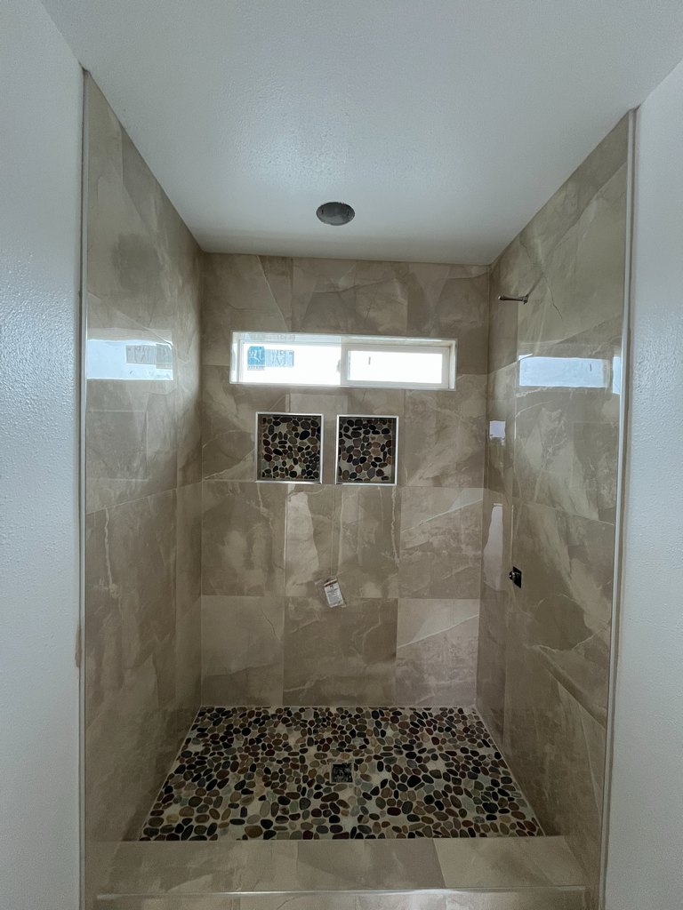 Pebble-floor shower with tiled walls