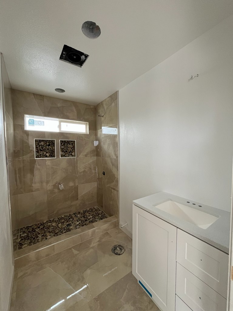 Bathroom vanity beside tiled walk-in shower