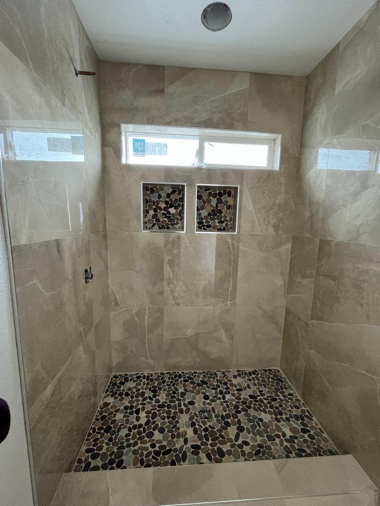 Windowed shower with pebble floor and niches