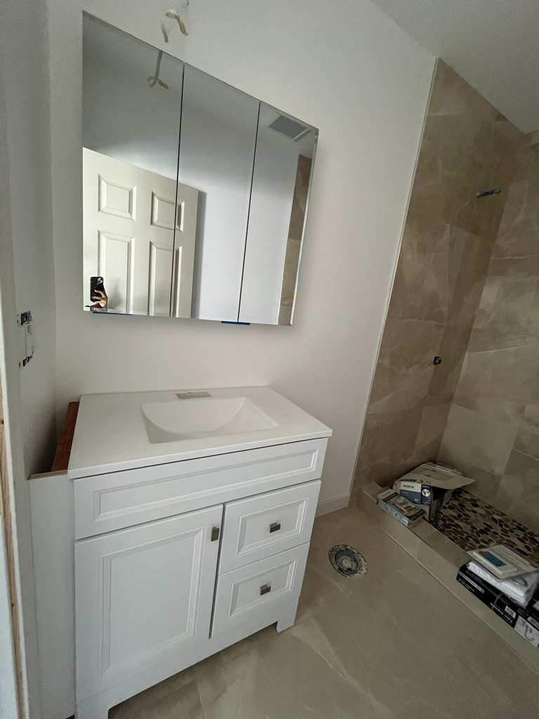 White vanity with mirrored wall cabinet