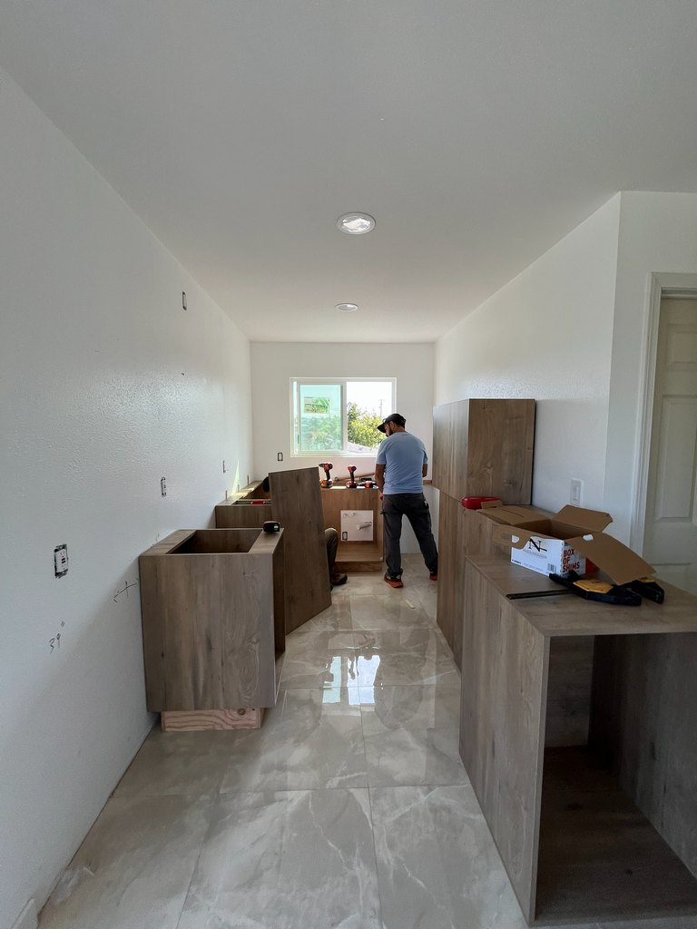 Worker installing kitchen base cabinets