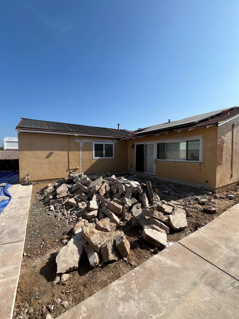 Residential patio area with concrete removed, exposing foundation prep area.