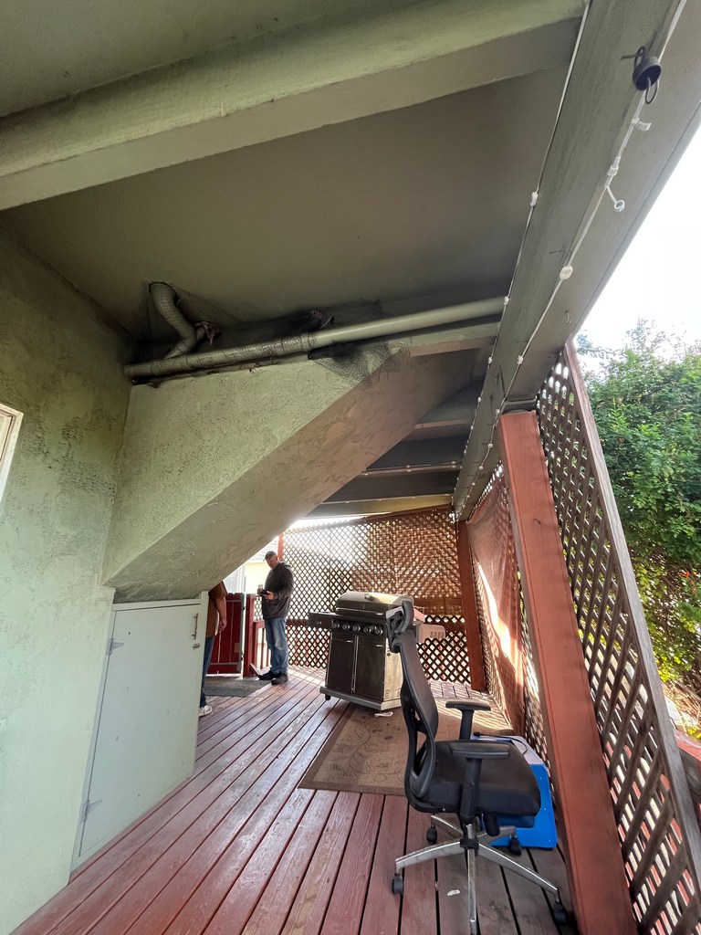 Existing under-deck area showing framing, lattice screening, and limited usable space before construction.
