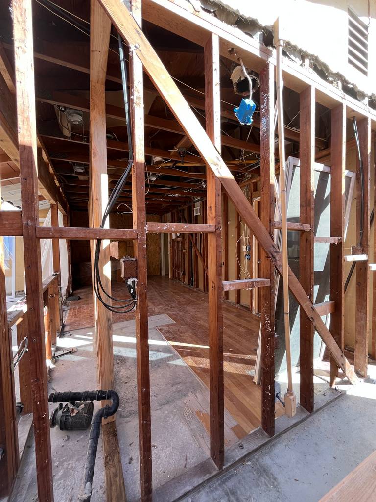Framed wall with exposed wiring showing interior remodel layout.