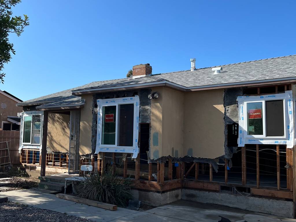 Existing exterior walls showing new window installations and framing modifications.