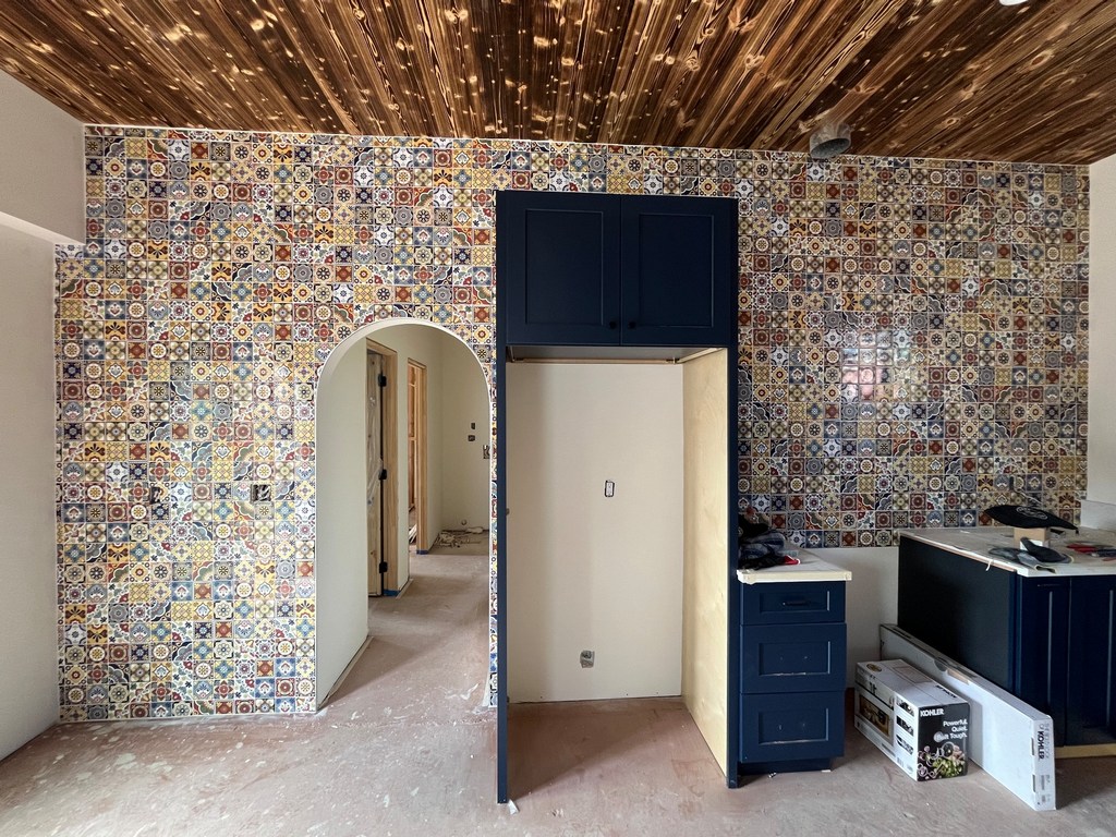 installation of a colorful patterned tile accent wall with arched doorway opening.