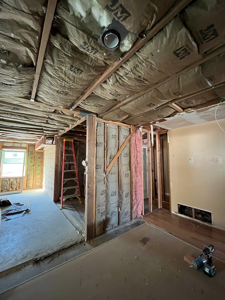 Insulated ceiling and exposed framing in remodel area before electrical and drywall.