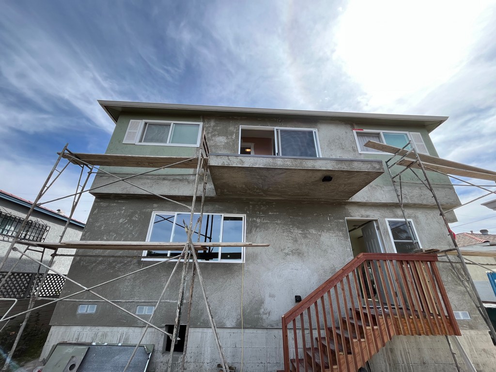 Exterior stucco finish detail showing texture, window integration, and final surface treatment.