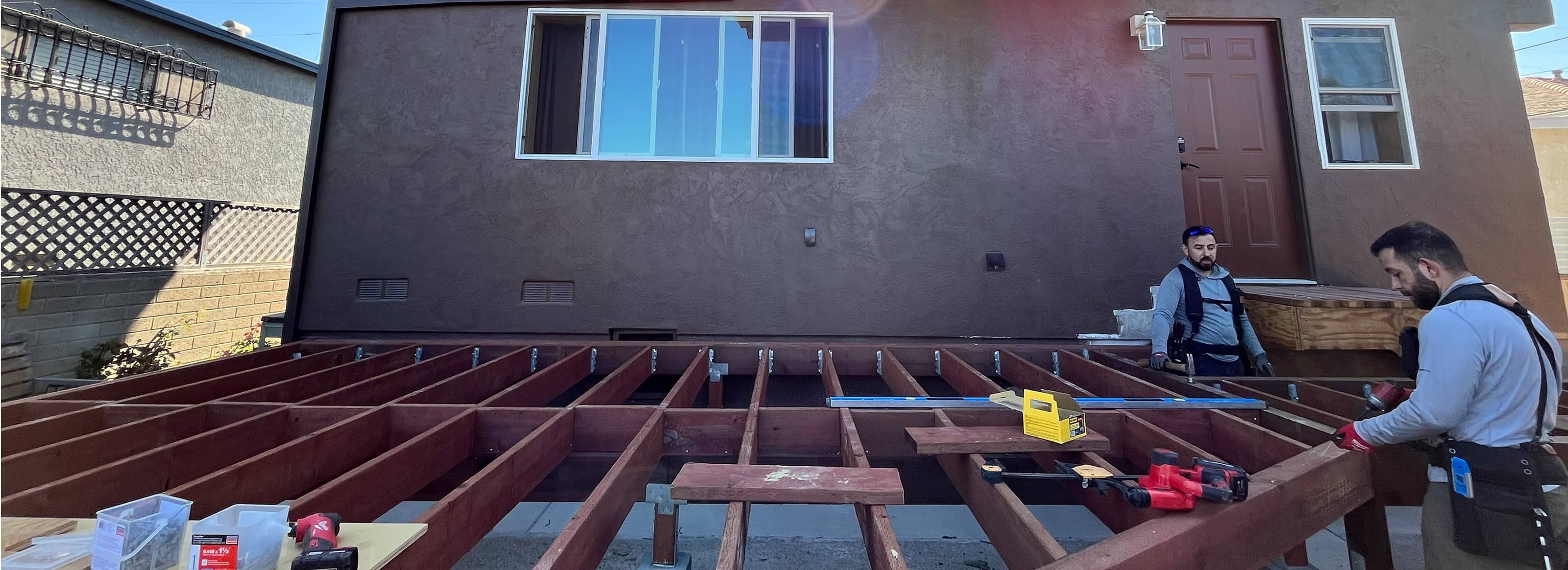 Pressure-treated deck framing behind ADU before decking installation
