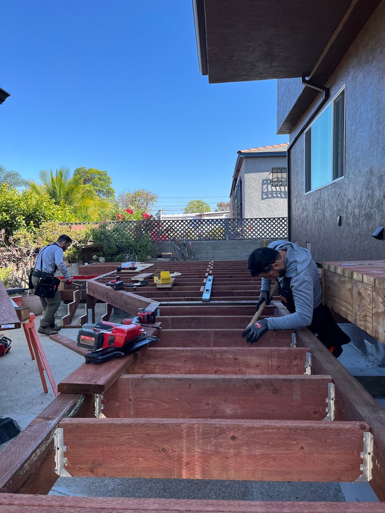 Crew leveling pressure-treated residential deck framing