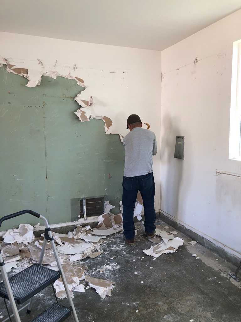 garage conversion worker removing the old wall