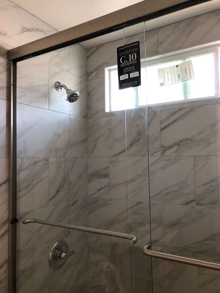 new-chrome-tub-enclosure-with-marble-panel-walls-in-front-unit-remodel 