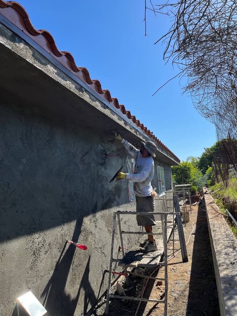 Professional Mason Applying Brown Stucco Coat - Home Addition Construction