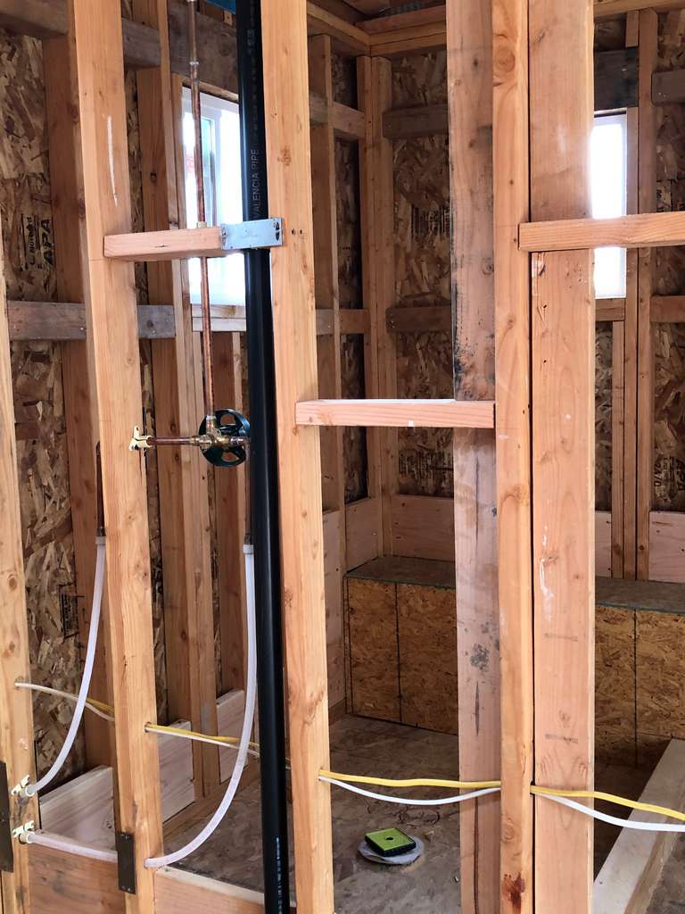 stud-framed-walls-and-plumbing-lines-for-the-bathroom-shower-in-Remodel-and-Home-Addition